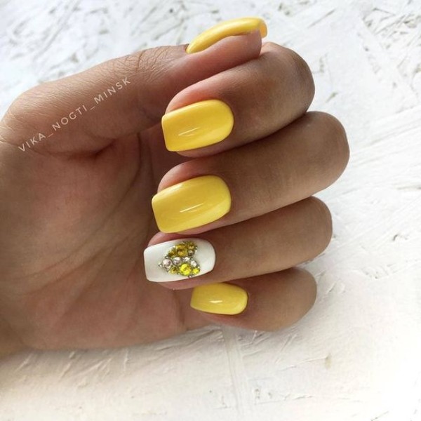 yellow and white nails with a rhinestones heart 