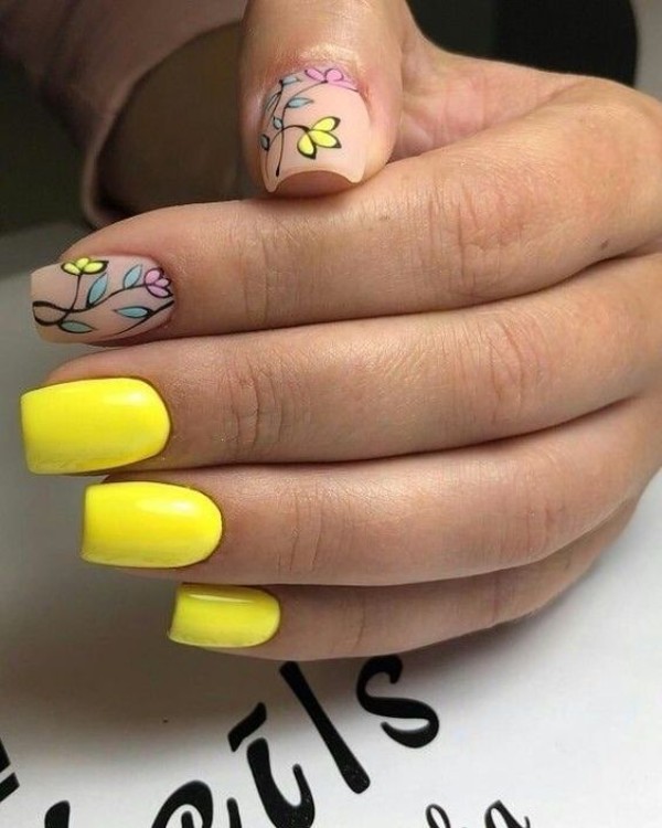 bright yellow manicure with two accent matte nails and colorful leaves and flowers