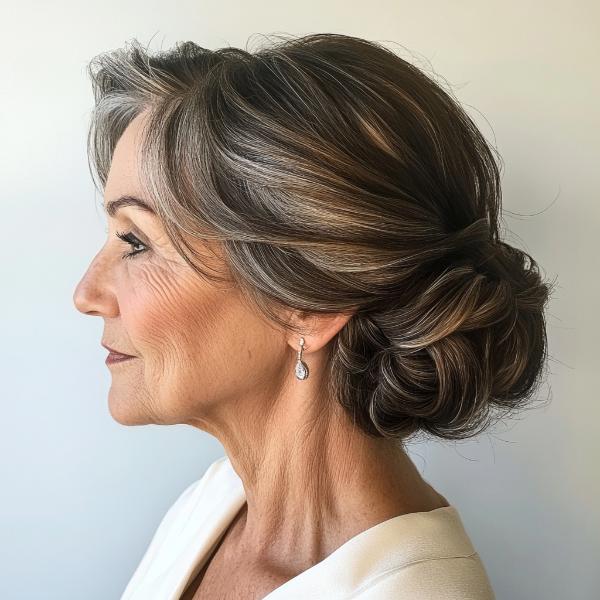 older woman gray and brown hair low bun with twists