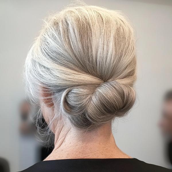 asymmetrical low bun older woman gray hair